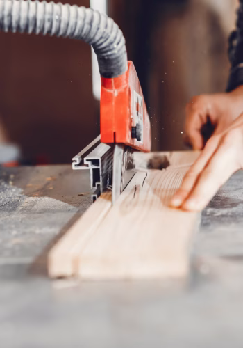 A man carves a tree. The carpenter works in a studio. An engineer provides a tree shape